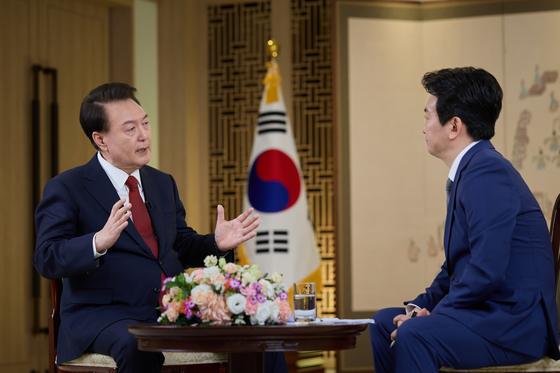 President Yoon Suk Yeol, left, speaks during an interview with public broadcaster KBS at the Yongsan presidential office in Seoul on Sunday. The interview was aired on Wednesday evening, ahead of the Lunar New Year holiday. [PRESIDENTIAL OFFICE]