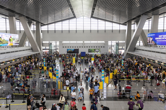 Passengers queue at airline counters in Ninoy Aquino International Airport in Manila, the Philippines, on Jan. 2, 2023. [REUTERS/YONHAP]