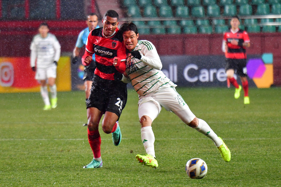 Jeonbuk Hyundai Motors' Hong Jeong-ho, right, vies for the ball with the Pohang Steelers' Jorge Luiz during a round of 16 match at the 2023-24 AFC Champions League at Pohang Steelyard in Pohang, North Gyeongsang on Tuesday. [NEWS1] 