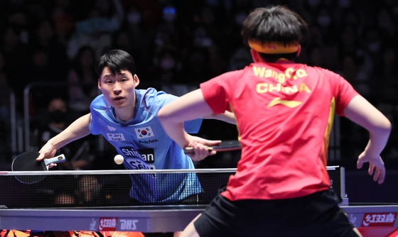 Korea's Jang Woo-jin, back, plays in a 2024 World Team Table Tennis Championships men's team match against China's Wang Chuqin at BEXCO Convention Centre in Busan on Saturday. [JOONGANG ILBO] 