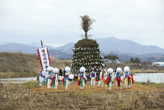 A Traditional Korean instrumental piece and dance known as pungmulnori is performed on Saturday before burning the daljip, or the moon house, in Cheongdo, North Gyeongsang. [SANGTAE KIM, COURTESY OF THE ARTIST AND JOHYUN GALLERY] 