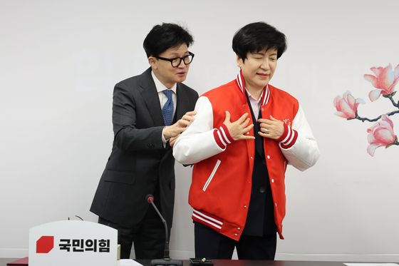 People Power Party (PPP) interim leader Chairman Han Dong-hoon, left, presents National Assembly Deputy Speaker Kim Young-joo, who recently defected from the Democratic Party, a new party jacket in a ceremony welcoming her to the PPP at its headquarter in Yeouido, western Seoul, Monday. [NEWS1]