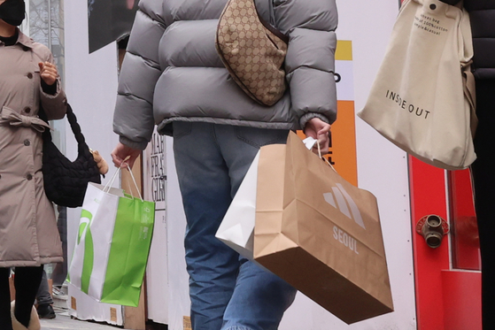 People shop in Myeong-dong, central Seoul, on Tuesday. Korea's gross national income per capita reached $33,745 last year, growing 2.6 percent from a year earlier, according to Bank of Korea data.[YONHAP]