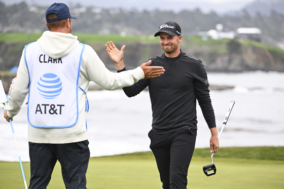 Wyndham Clark high-fives his caddie at the 18th green during the third round of the AT&T Pebble Beach Pro-Am at Pebble Beach Golf Links on Feb. 3 in Pebble Beach, California. [GETTY IMAGES]