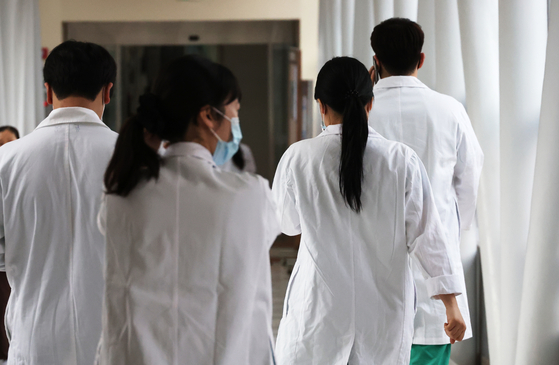 Medical professionals walk inside a general hospital in Seoul on Thursday. [YONHAP]