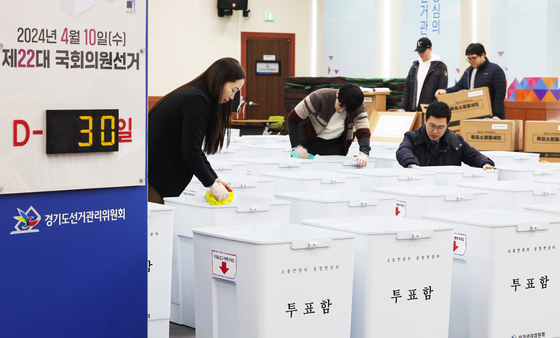 A sign at the Yeongtong District Election Commission office in Suwon, Gyeonggi, shows there are 30 days remaining before the April 10 general election as commission officials inspect ballot boxes. [YONHAP]