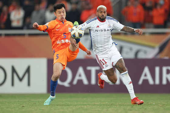 Yokohama F. Marinos' Yan Matheus, right, vies for the ball with Shandong Taishan's Zheng Zheng during a 2023-24 AFC Champions League quarterfinal at Jinan Olympic Sports Center Stadium in China on March 6. [AFC]