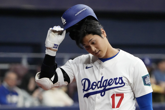 Los Angeles Dodgers' designated hitter Shohei Ohtani returns to the bench after striking out during the second inning of an exhibition game between the Los Angeles Dodgers and Kiwoom Heroes at Gocheok Sky Dome in western Seoul on Sunday.  [AP/YONHAP]