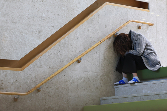 A patient in a general hospital in Seoul cries and sits down on Thursday. [YONHAP] 