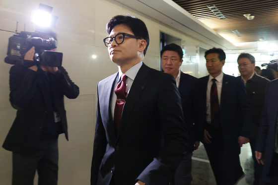 Han Dong-hoon, the leader of the conservative People Power Party, walks down a corridor inside Severance Hospital in Seodaemun District, western Seoul, on his way to a meeting with the leadership of the national medical professors' council on Sunday afternoon. The council requested the party's help in mediating potential talks with the government, according to Han. [JOINT PRESS CORPS]