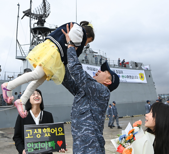 A soldier of the Cheonghae Unit, returning home from a six-month deployment to waters near the Gulf of Aden, is greeted by his daughter at a naval base on Monday. The ROKS Yang Man-chun destroyer, carrying the 41st rotation of the anti-piracy Cheonghae Unit, left a naval base in Busan in September last year. South Korea first deployed the Cheonghae Unit in 2009. [YONHAP]
