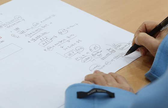 A mother takes notes at a briefing session held at Jongro Academy in southern Seoul on Feb. 7 about admissions to medical schools following the expanded enrolment quota. [YONHAP]