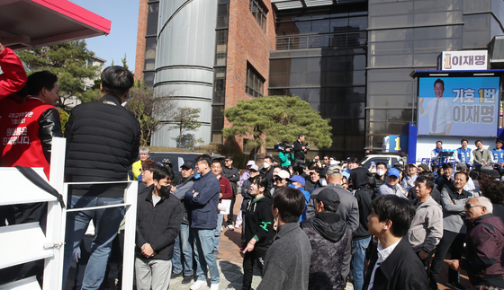 Former Land Minister Won Hee-ryong, left, the People Power Party’s candidate for Incheon’s Gyeyang-B District, crosses paths with his Democratic Party rival Lee Jae-myung, chief of the liberal party, in their campaign trail in Gyeyang District, Incheon, Sunday afternoon with 10 days left until the general election. They also attended the same Easter service at a church in Gyeyang District earlier that morning. [NEWS1]