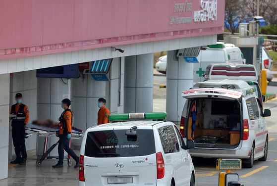 Paramedics transport a patient to an emergency room at a general hospital in Daejeon on Sunday noon. [KIM SUNG-TAE]