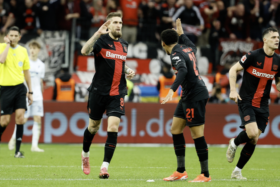 Bayer Leverkusen's Robert Andrich, front left, celebrates scoring with his teammate Amine Adli during a Bundesliga match against TSG Hoffenheim in Leverkusen, Germany on Saturday. [XINHUA/YONHAP] 