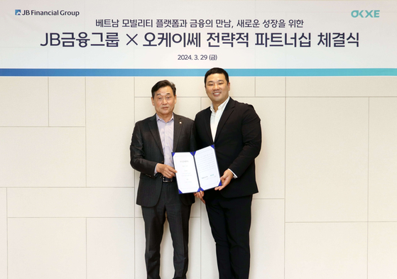 JB Financial Group CEO Kim Ki-hong, left, and Vietnamese motorbike transaction platform OKXE CEO Kim Woo-seok at a signing ceremony for the two companies’ strategic partnership on Friday [JB FINANCIAL GROUP]