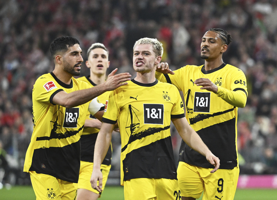 Borrusia Dortmund's Julian Ryerson, front center, celebrates after scoring his side's second goal during a Bundesliga match against Bayern Munich in Munich, Germany on Saturday. [AP/YONHAP]