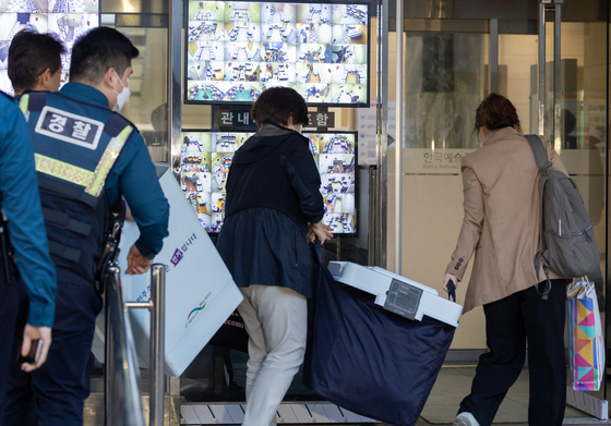 Election staffers, escorted by police, move ballot boxes to a National Election Commission office in Jongno District in central Seoul after the second and final day of the early voting period for Wednesday’s general election wrapped up Saturday evening. [YONHAP] 