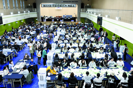 Election staffers sort ballots at a counting station set up at a high school in Yongsan District, central Seoul, to tally votes for Korea’s parliamentary elections on Wednesday evening. [NEWS1]