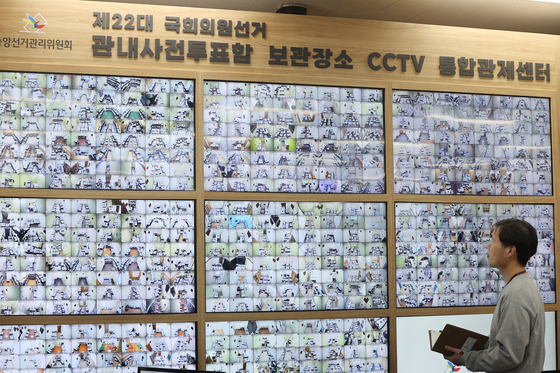 An official at the National Election Commission's headquarters in Gwacheon, Gyeonggi, monitors CCTV footage of ballot boxes used in early voting that are being stored in various locations on Sunday. [YONHAP]