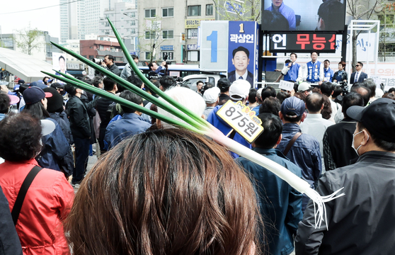 A supporter for the liberal Democratic Party (DP) wears a hairband with a green onion-shaped ornament at DP candidate Kwak Sang-eon's campaign rally in Jongno District, central Seoul, on Monday. [KIM SEONG-RYONG] 