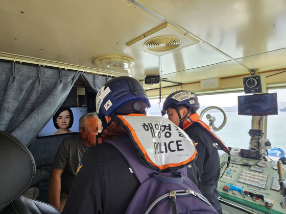 A Mokpo Coast Guard officer explains to the captain of a ship carrying large engines why his vessel was being searched on April 11. 