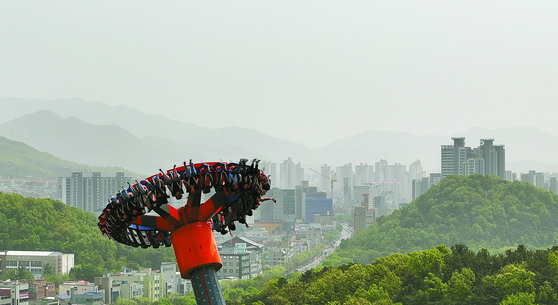 While yellow dust blown from China and Mongolia is smothering Korea, people enjoy the pendulum spinning ride at an amusement park in Daegu on Wednesday. The city’s fine dust concentration reached 205 micrograms per cubic meter as of 5 p.m. on the same day, with its air quality level reaching the “very bad” level. [YONHAP]