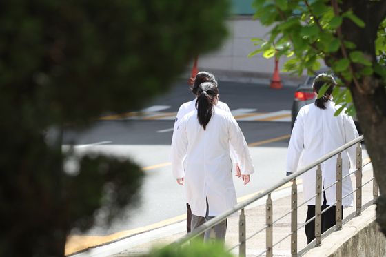 Doctors walk near a hospital in Seoul on Thursday. [NEWS1] 