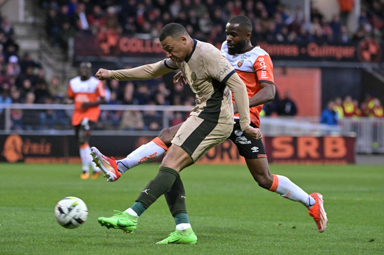 Paris Saint-Germain forward Kylian Mbappe, front, shoots during a Ligue 1 match against Lorient at the Stade du Moustoir in Lorient, France on Wednesday. [AFP/YONHAP]