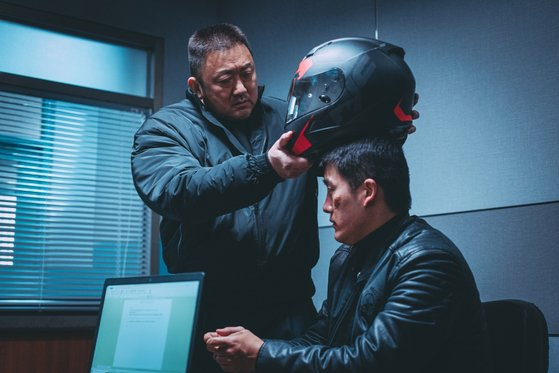In ″The Roundup,″ a monster detective named Ma Seok-do, left, puts a helmet on a criminal. The ensuing intense interrogation process has become a trademark along with the line, ″To the room of truth.″ [ABO Entertainment]