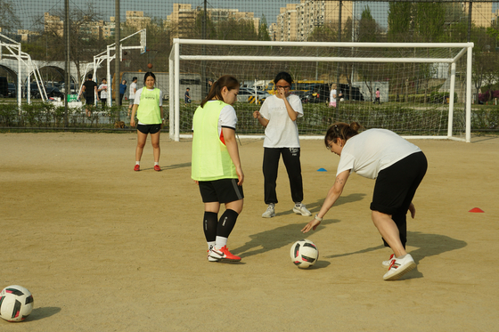 A player places the ball back on the pitch after chasing it down. [SEOUL CALCIO FC]