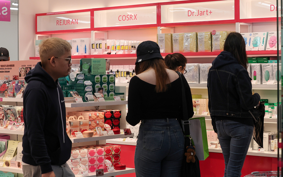 Tourists look at products displayed at a store in Myeong-dong, central Seoul, on May 7. [NEWS1]