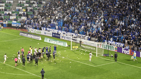 FC Seoul and Incheon United react to spectators who threw water bottles on the pitch after a K League 1 match at Incheon Football Stadium in Incheon on May 11. [YONHAP] 