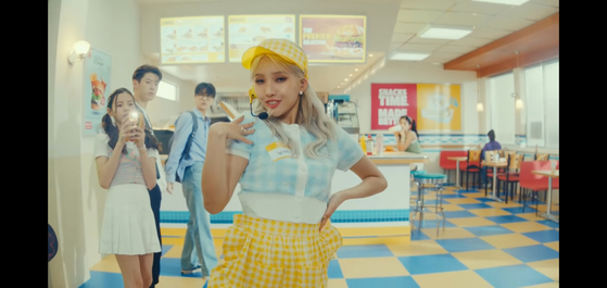 Soyeon of (G)I-DLE dressed as a waitress in an American-style burger joint in her music video for "Beam Beam” (2021). [SCREEN CAPTURE]