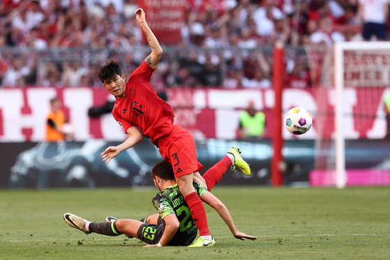 Wolfsburg’s Jonas Wind, left, in action against Bayern Munich’s Kim Min-jae during the match between Bayern Munich and VfL Wolfsburg in Munich, Germany on Sunday. [EPA/YONHAP]