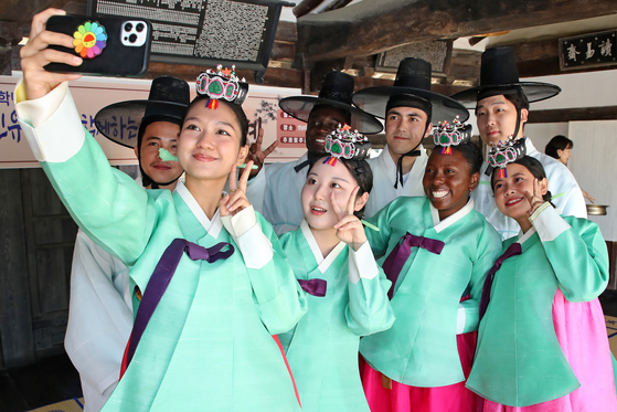 International students wearing hanbok, or Korean traditional dress, take selfies during a Coming of Age Day event held at a traditional house in Yeungnam University in Gyeongsan, North Gyeongsang, on Friday. The Coming of Age Day fell on Monday this year. [NEWS1] 