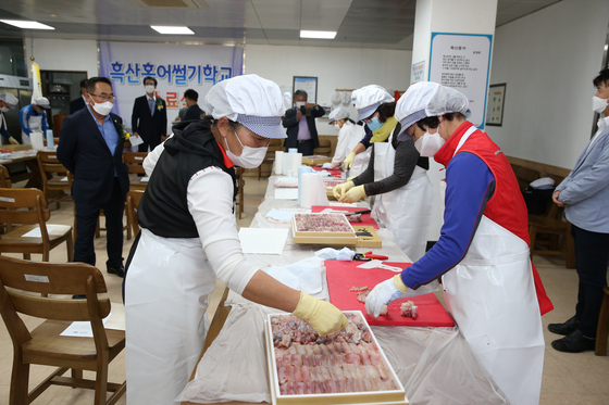 Students at the hongeo cutting school on Heuksan Island practice slicing skate. [JOONGANG PHOTOS] 