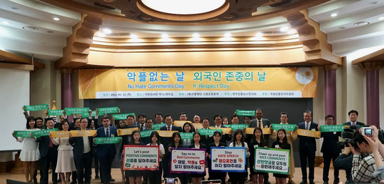 Participants of the declaration ceremony for K-Respect Day and No Hate Comments Day, including the founder of the Sunfull Foundation Min Byoung-chul, center in the second row, and students from Seoul Foreign School, first row, hold banners to respect foreigners and root out malicious comments online at the National Assembly members' office building in Yeouido, western Seoul, on Thursday. [SUNFULL FOUNDATION] 