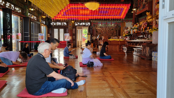 A group of tourists meditate at the Bongeun Temple in southern Seoul on May 23 as part of a tour event dubbed “KOREA invites U,” hosted by the Ministry of Culture, Sports and Tourism in collaboration with the Korea Tourism Organization. [YOON SO-YEON]