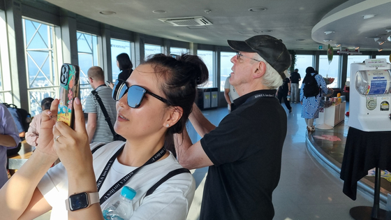 A group of tourists take photos of Seoul at the N Seoul Tower in central Seoul's Namsan on May 23 as part of a tour event dubbed “KOREA invites U,” hosted by the Ministry of Culture, Sports and Tourism in collaboration with the Korea Tourism Organization. [YOON SO-YEON]