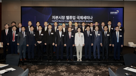 Attendees of the Capital Market Value-up International Seminar, including Financial Supervisory Service Gov. Lee Bok-hyun, sixth from left in the first row, Korea Financial Investment Association Chairman Seo Yoo-seok, eighth from left, and Financial Services Commission Chairman Kim Joo-hyun, tenth from left, pose for a photo at the venue in western Seoul on Tuesday. [KOREA FINANCIAL INVESTMENT ASSOCIATION]