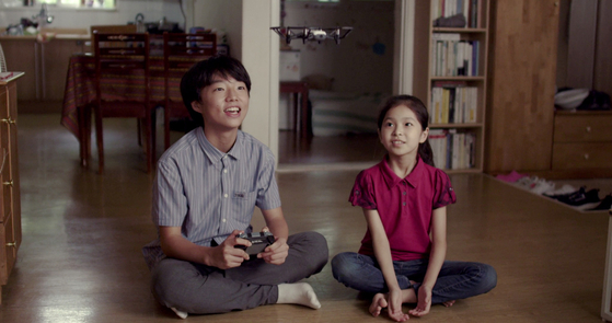 Children seen sitting in a crossed-leg posture, or yangbandari, from a scene of film ″Scattered Night″ (2019). [CINESOPA]