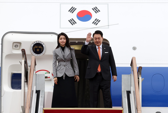 President Yoon Suk Yeol, right, and first lady Kim Keon-hee wave as they enter the presidential jet at Seoul Air Base in Seongnam, Gyeonggi, to head for a state visit to the Netherlands on Dec. 11. [JOINT PRESS CORPS]