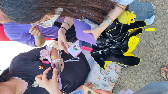 Fans exchange photo cards from the limited package given out to members of BTS's fan club ARMY at the 2024 Festa held on June 13 at the Seoul Sports Complex in southern Seoul. [YOON SO-YEON]