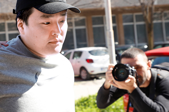 Do Kwon being taken to court in handcuffs, to face charges of forging official documents, in Montenegro. [REUTERS/YONHAP]