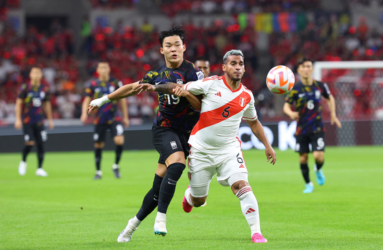 Korea's Oh Hyeon-gyu, left, vies for the ball during a match against Peru at the Asiad Main Stadium in Busan on the June 16, 2023. [YONHAP]