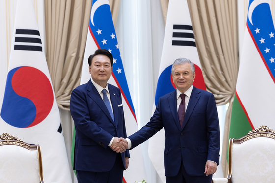 President Yoon Suk Yeol, left, and Uzbek President Shavkat Mirziyoyev shake hands at their bilateral summit at the presidential palace in Tashkent, Uzbekistan, on Friday. [PRESIDENTIAL OFFICE]