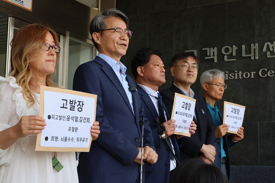 Choi Jae-young, second from left, the Korean American pastor who gifted a luxury handbag to first lady Kim Keon Hee, speaks to the press at the Gwacheon government complex as a civic group submitted a petition against President Yoon Suk Yeol, the first lady and Anti-Corruption and Civil Rights Commission Chairperson Yoo Cheol-hwan for alleged bribery and dereliction of duty on Monday. [YONHAP] 