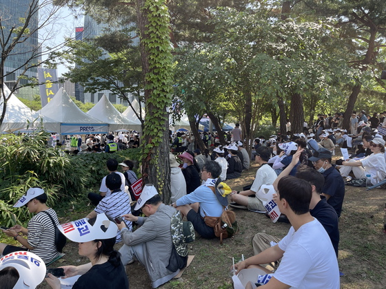 Protesting doctors take their seats underneath trees in a rally on Tuesday in Yeouido, western Seoul. [LEE SOO-JUNG]