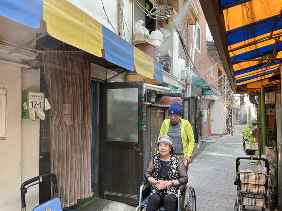66 year-old Jeon Soo-yong and 71 year-old Cho Myeong-soon cool off the heat under a cooling fog system in Jongno District, Seoul on Monday.